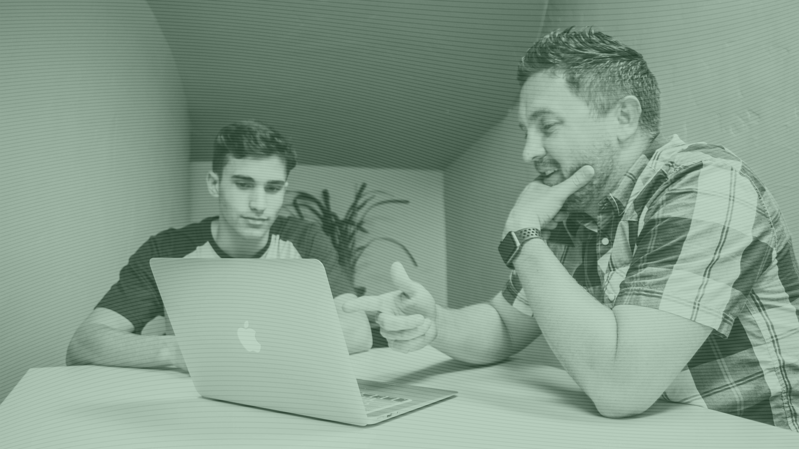 Photo of a father and son looking at a laptop screen