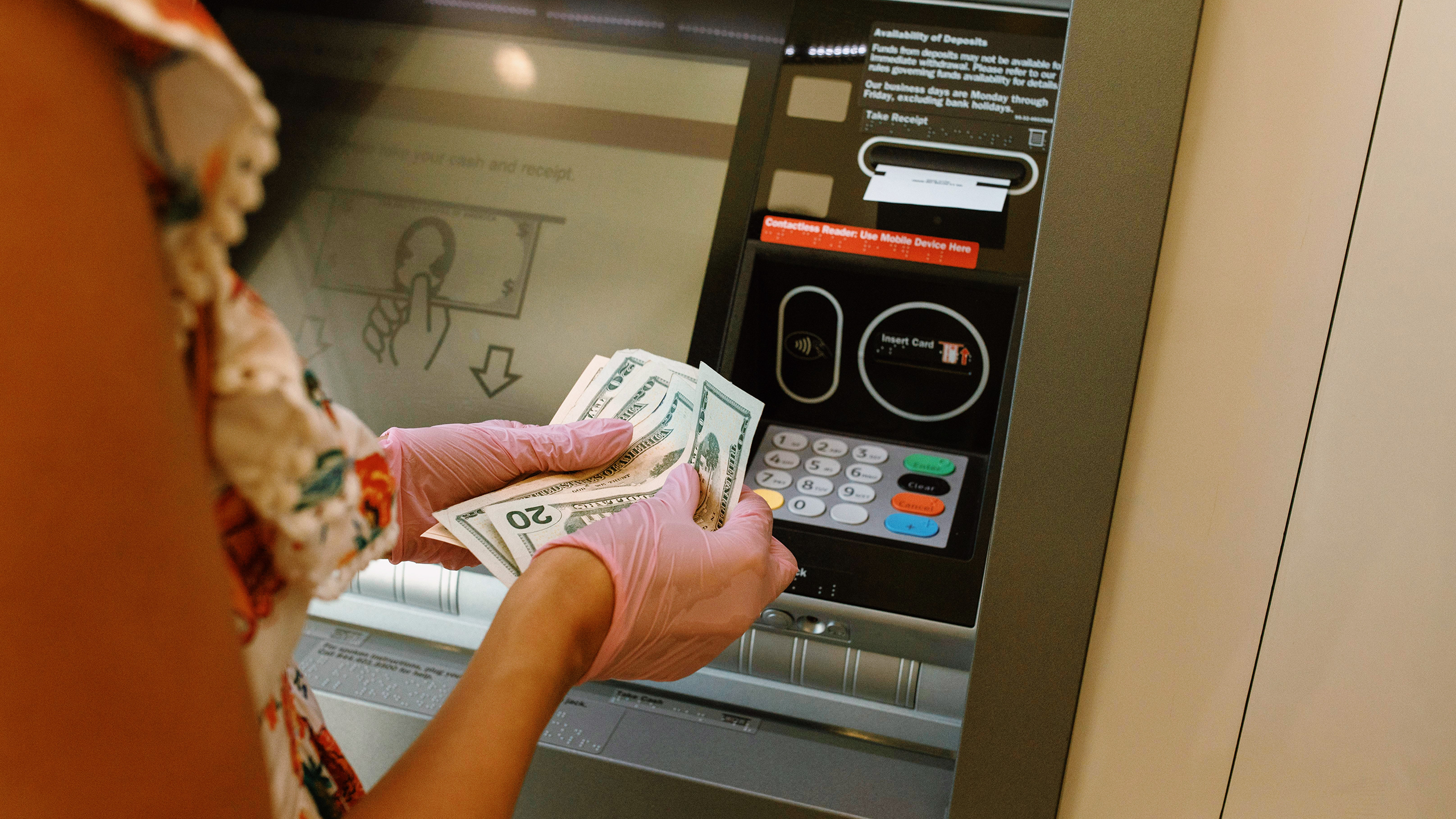 Photo of a person using a bank ATM machine