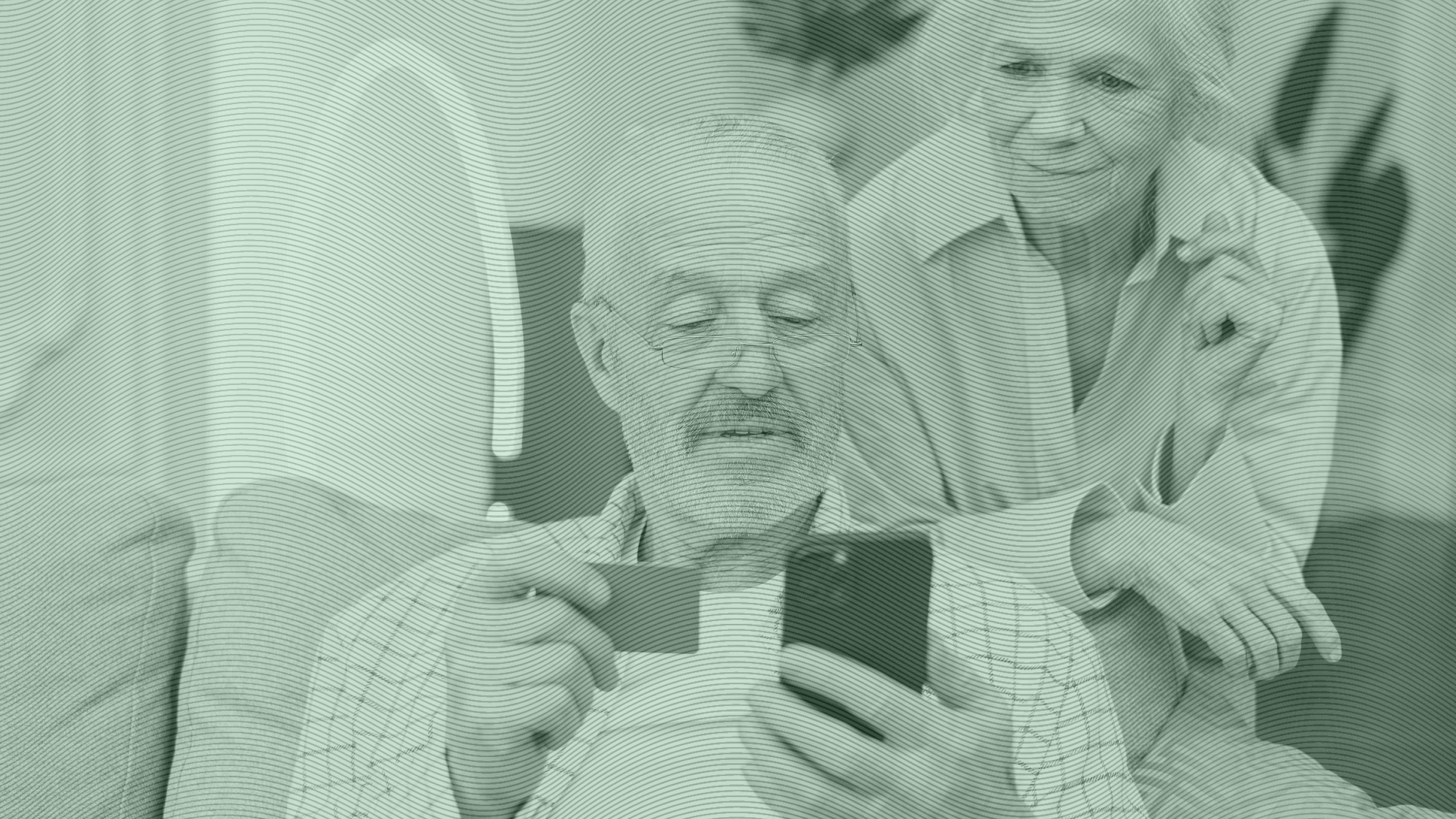 Photo of an elderly couple looking at a phone and credit card