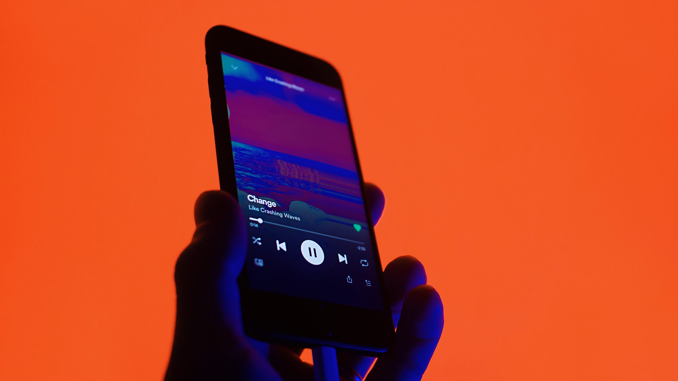 Photo of a person holding a phone with the Spotify app open