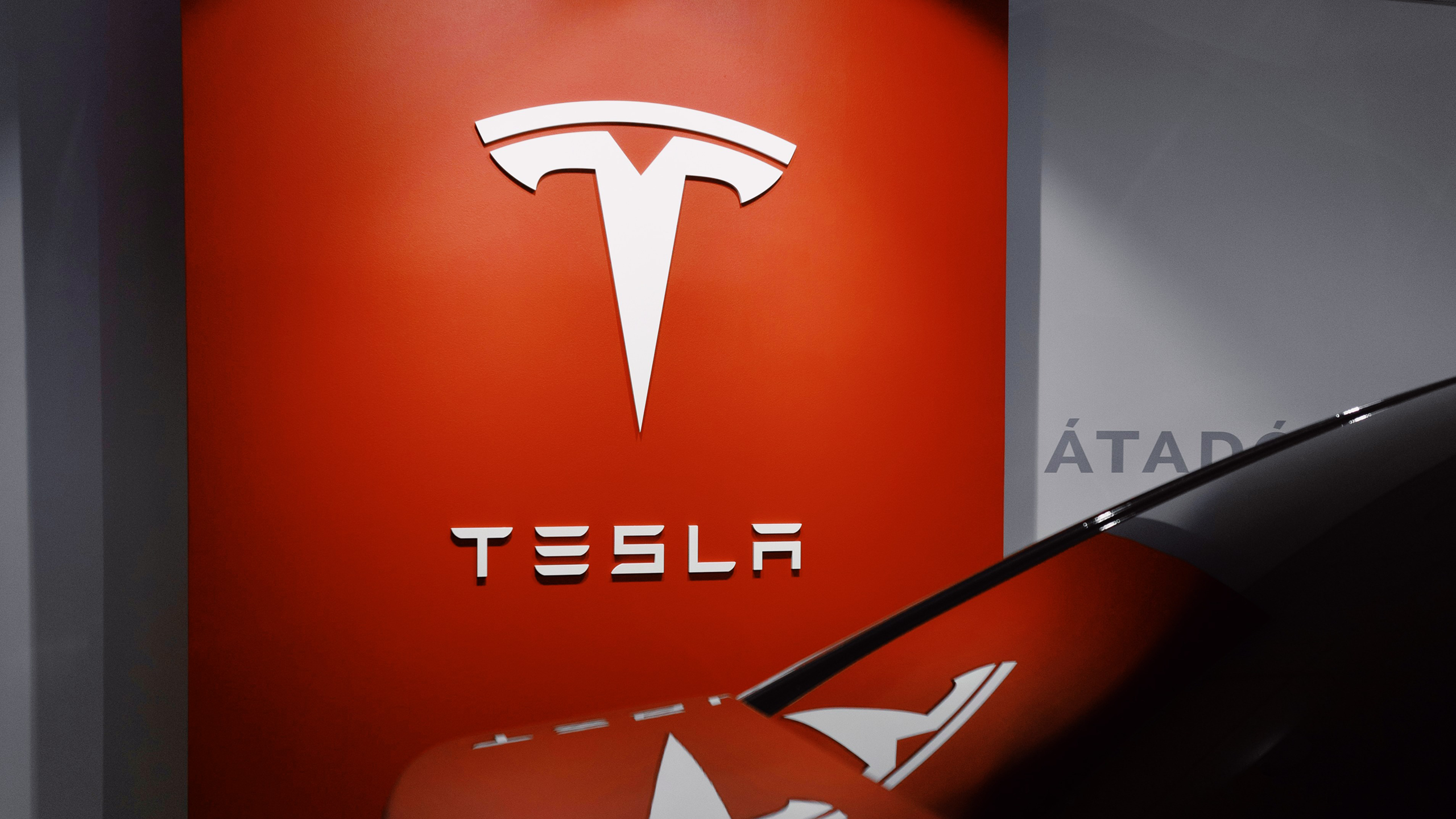 Photo of a Tesla logo on a wall
