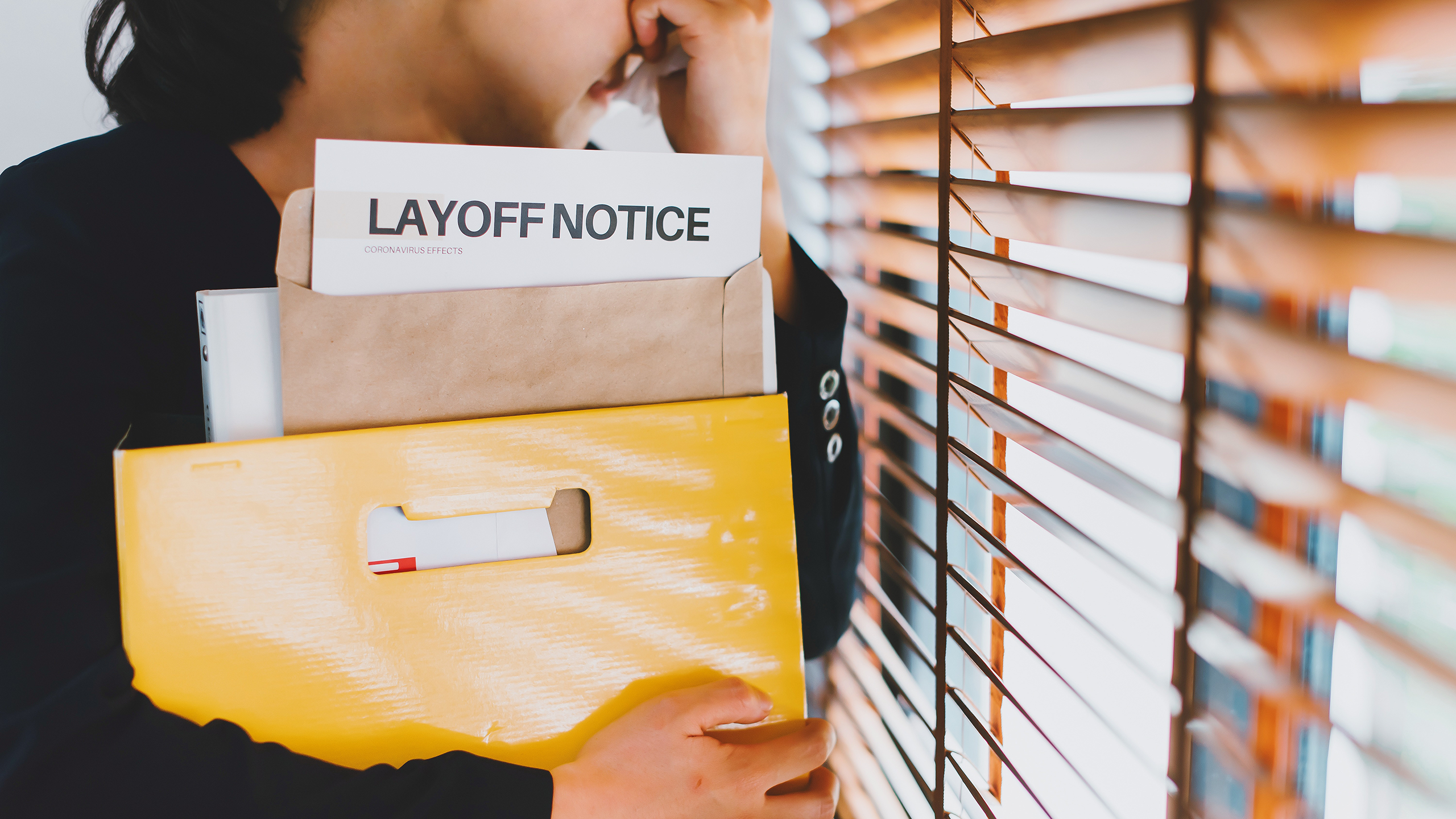 Photo of a person holding a layoff notice