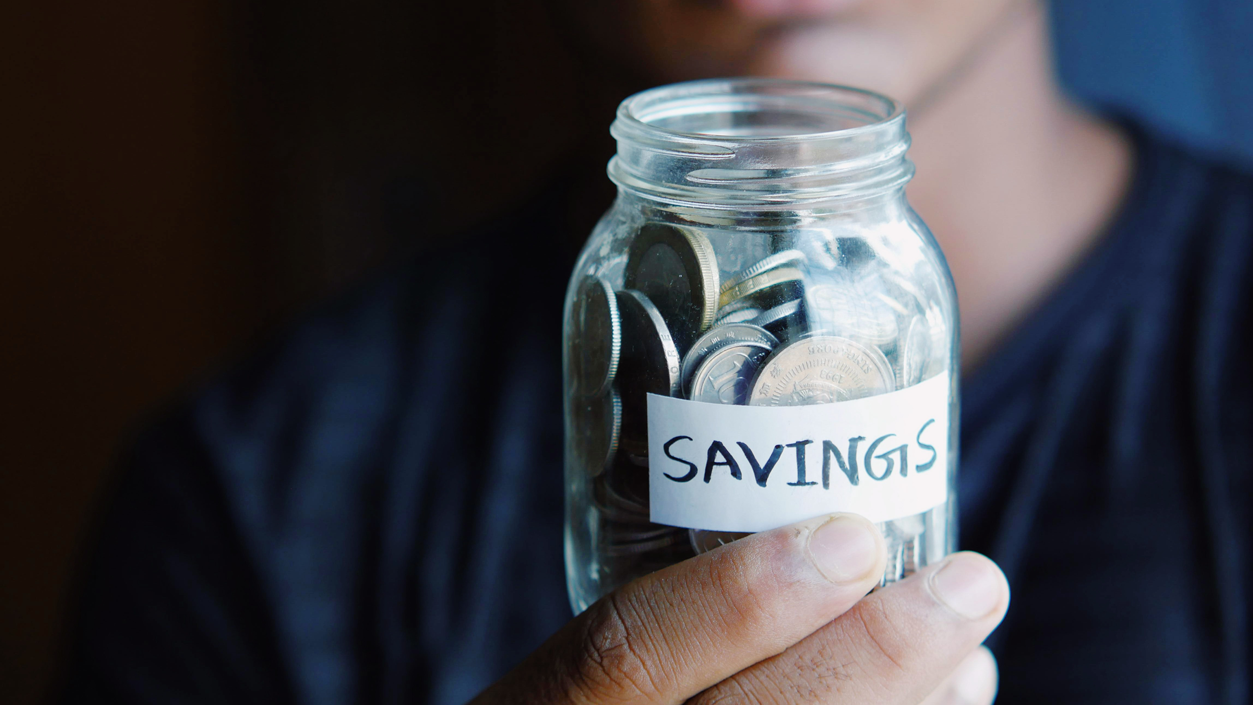 Photo of a person holding a savings jar