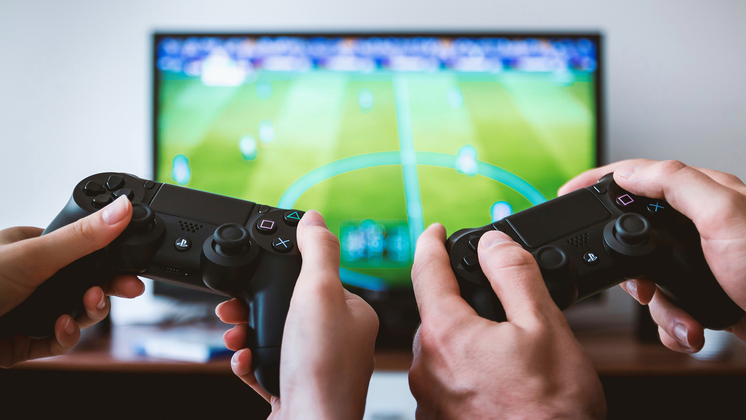 Photo of two video game controllers in front of a TV