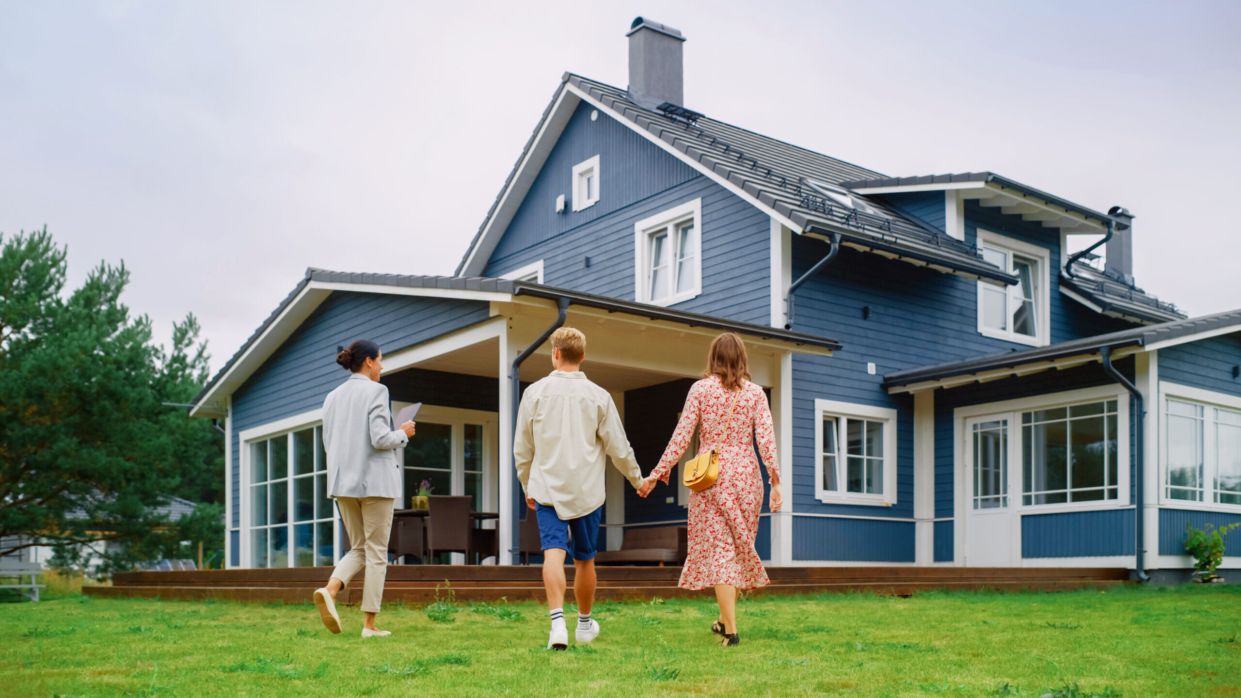 A young couple views a property for sale with a real estate agent.