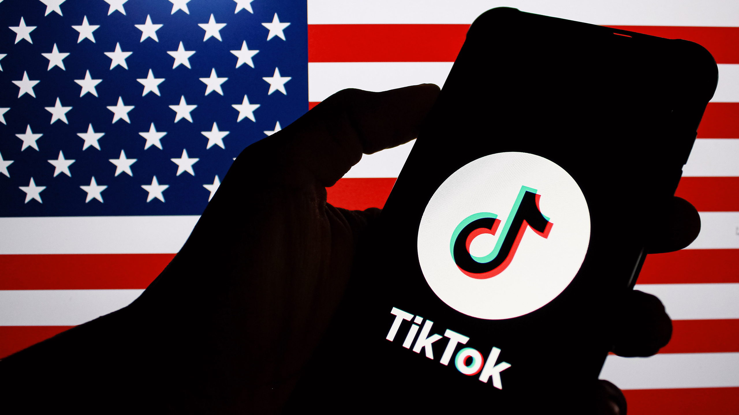 Photo of the TikTok app on a phone in front of a US flag