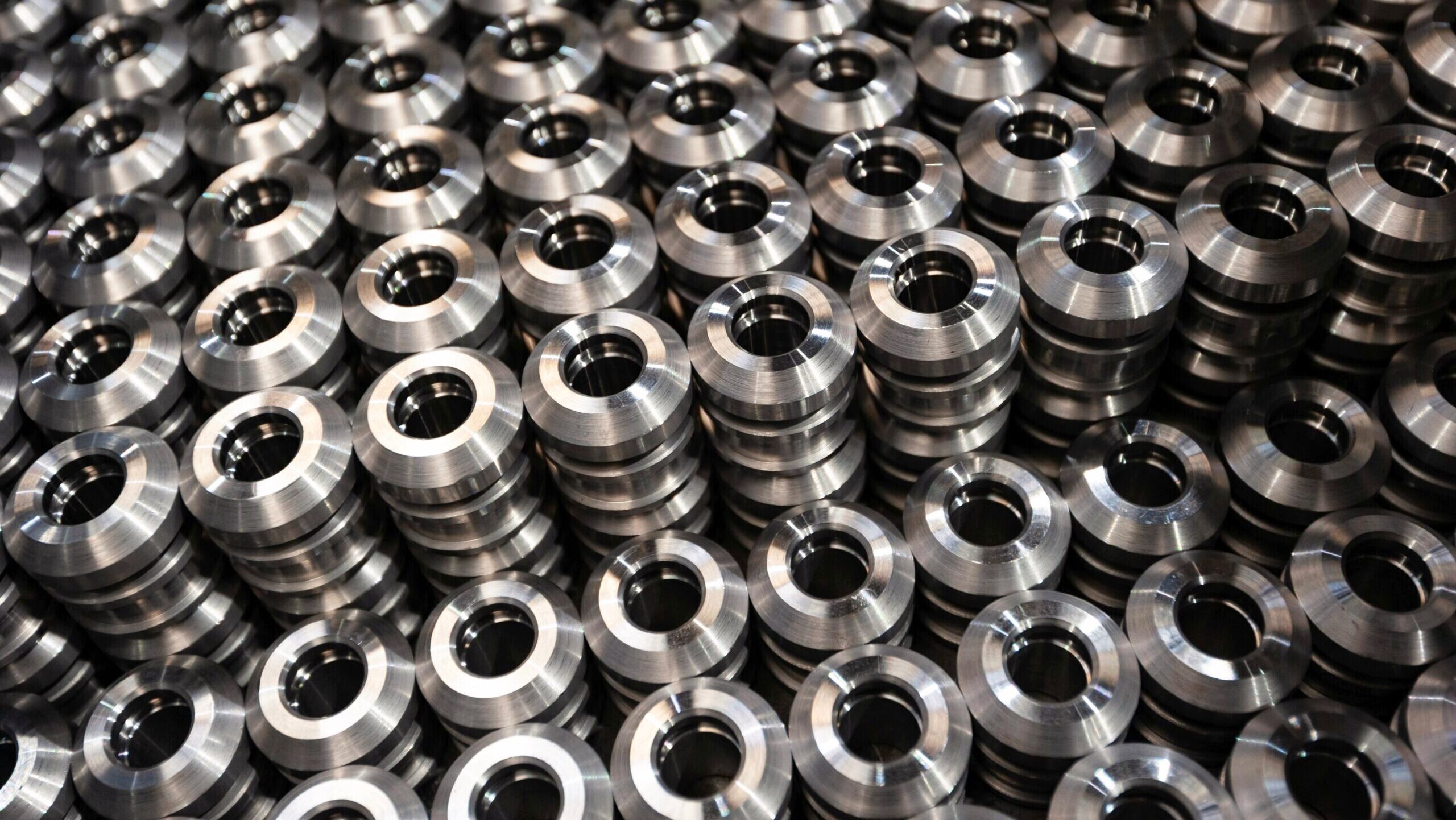 Several tightly packed stacks of metal flanges are shown up close.