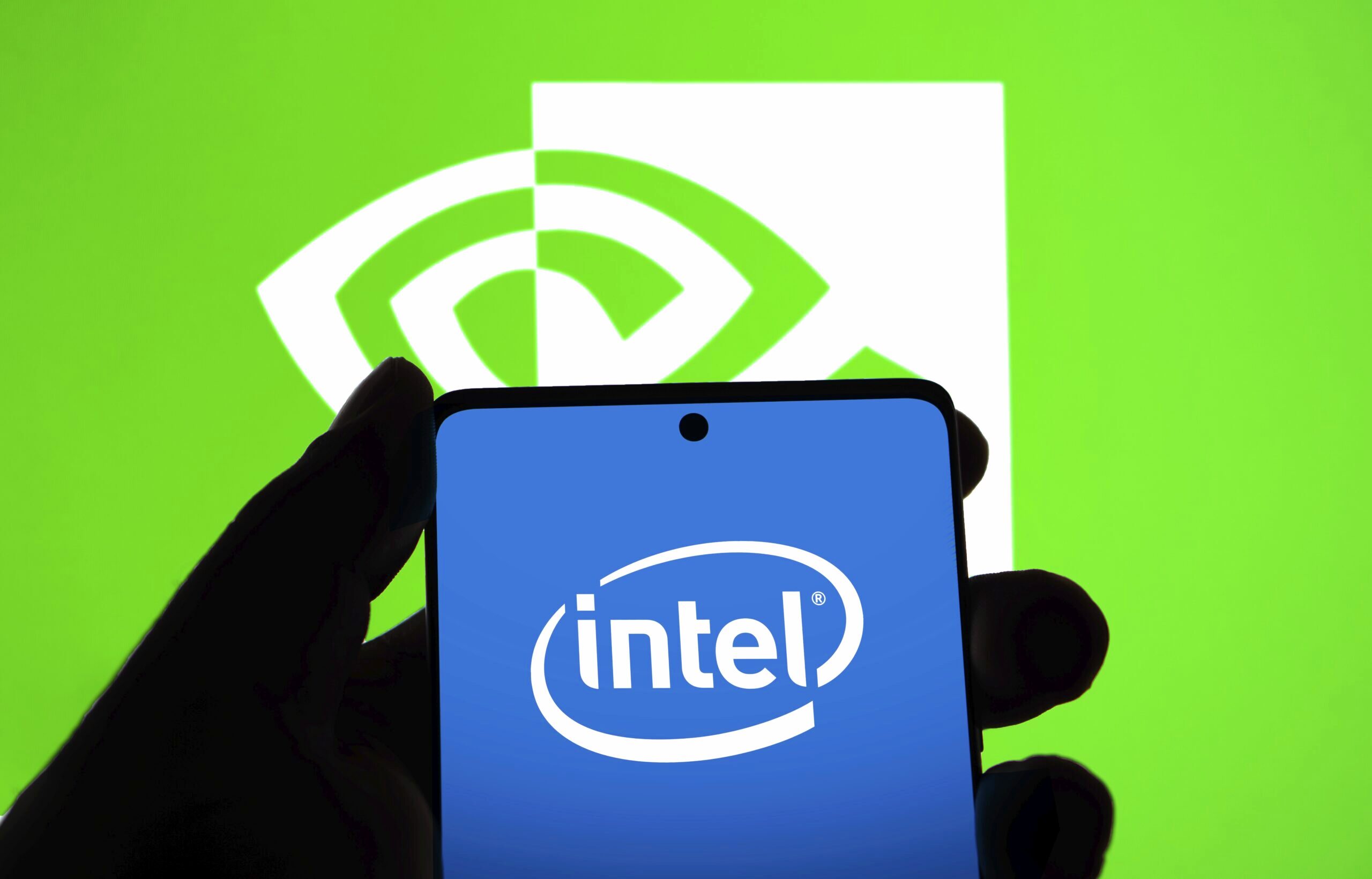 The Intel logo is displayed on a phone screen in front of the Nvidia logo.