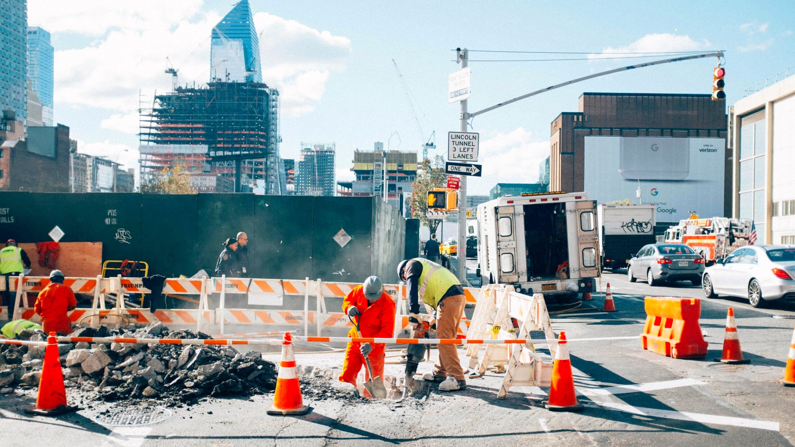 A group of construction workers are seen shoveling on a street in New York City.