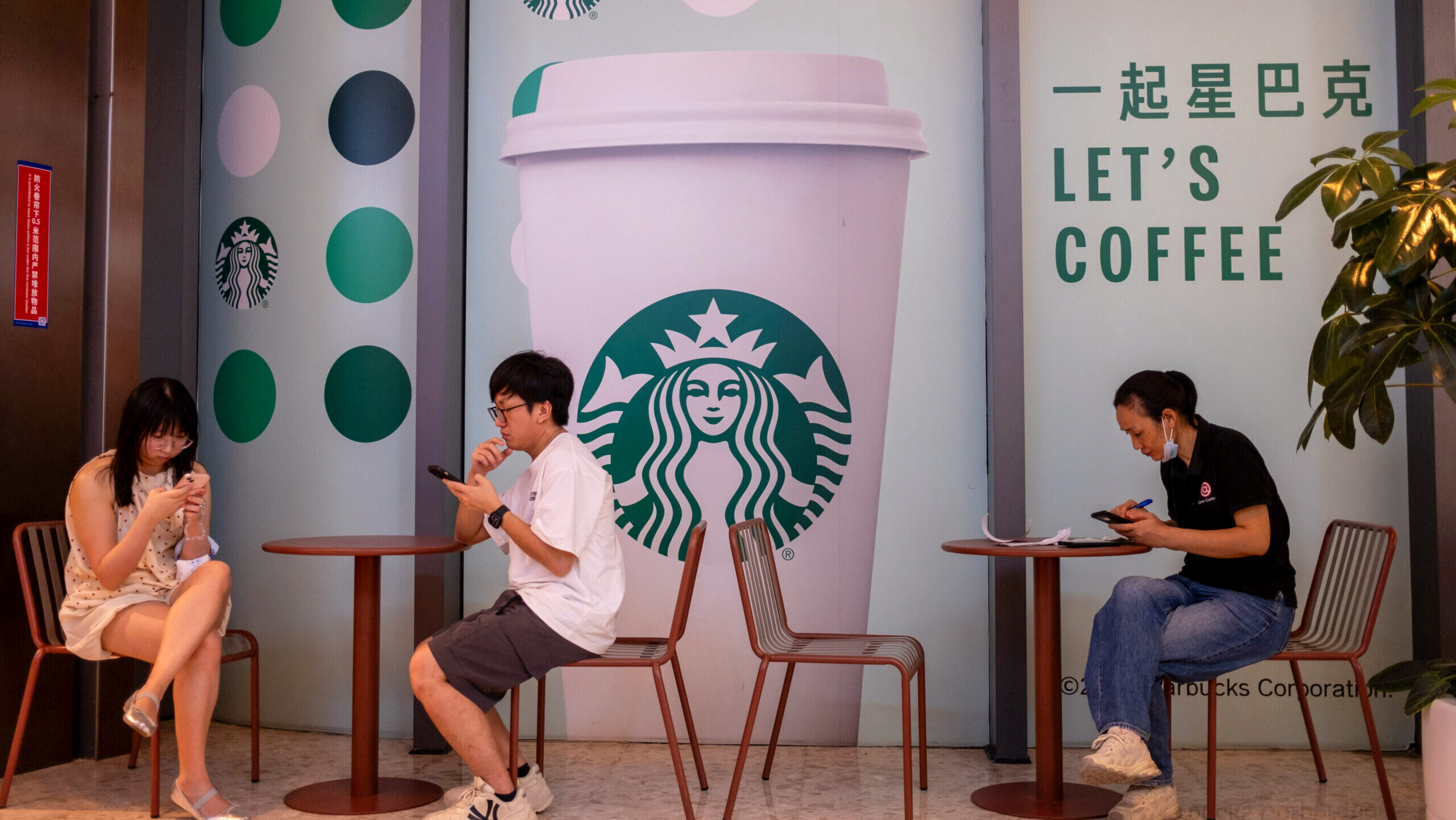 Customers are shown sitting outside a Starbucks location in Shenzen, China.