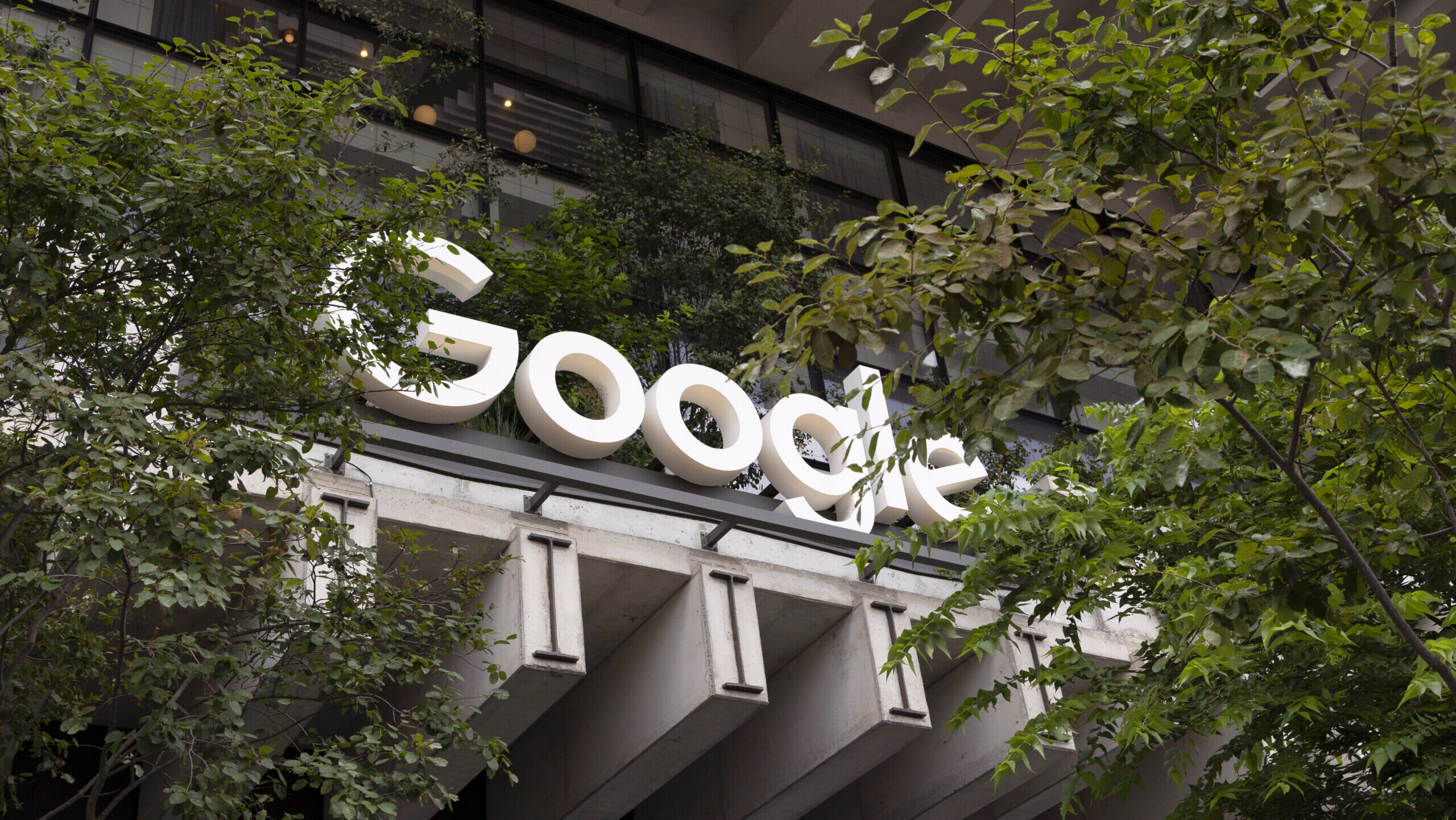 The 'Google' letters on the Alphabet subsidiary's offices in lower Manhattan are shown surrounded by trees and plants.
