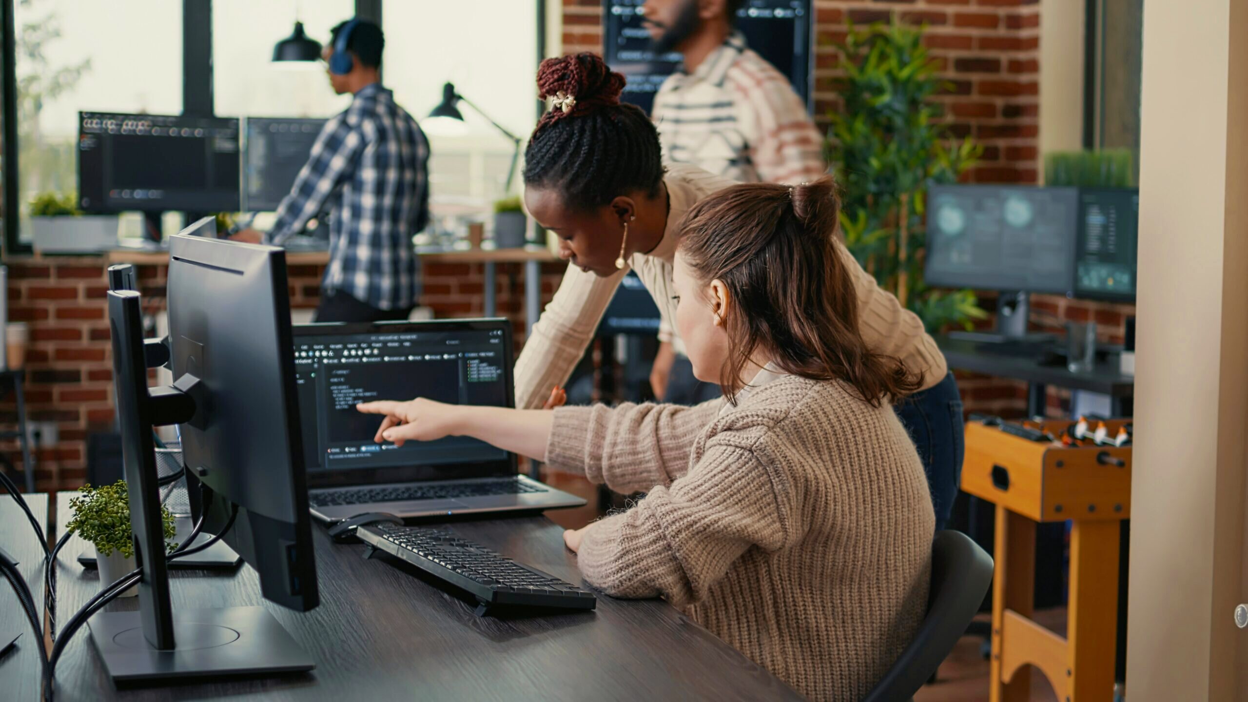 Photo of people looking at code on a computer