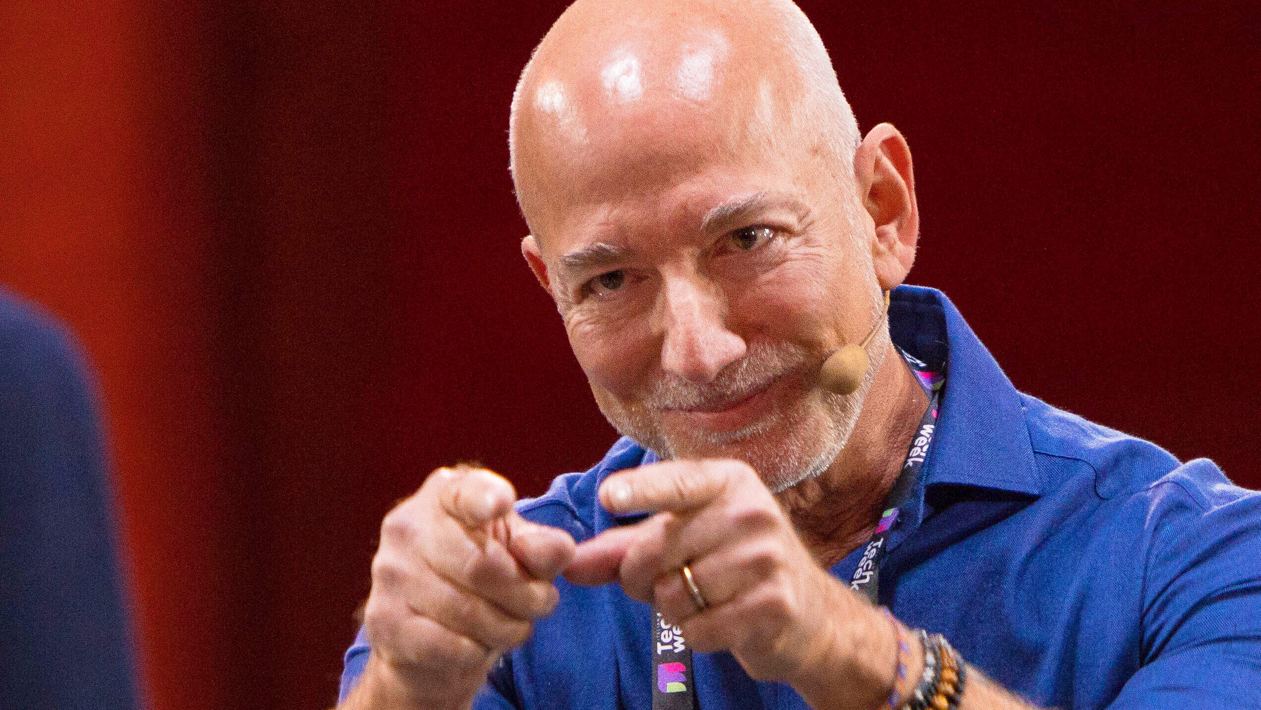 Amazon founder Jeff Bezos smiles and points on stage at a tech conference in Italy in October 2025.