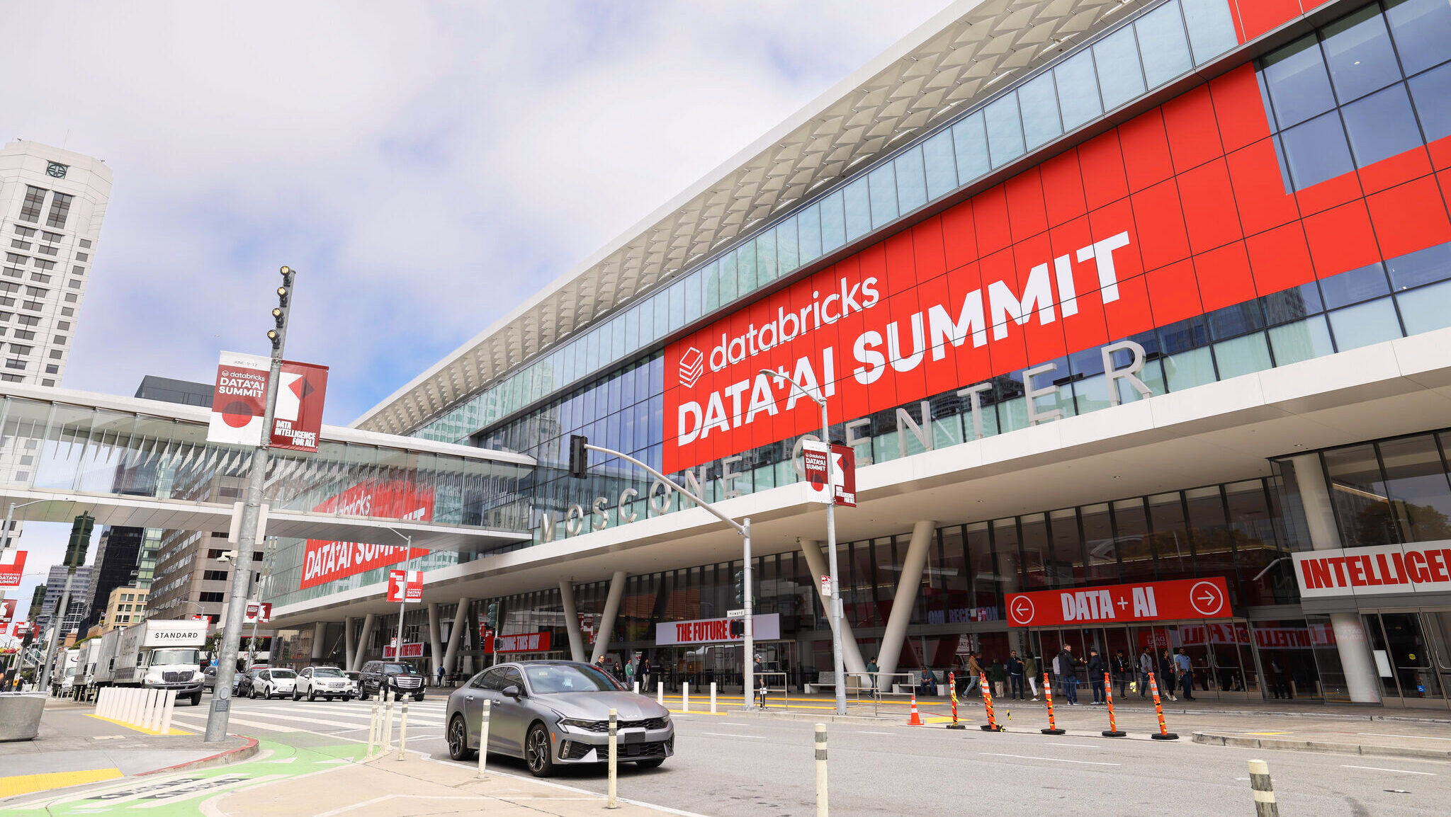 Large signage promoting Databricks' Data and AI Summit at San Francisco's Moscone Center are shown on the glass windows of the venue.