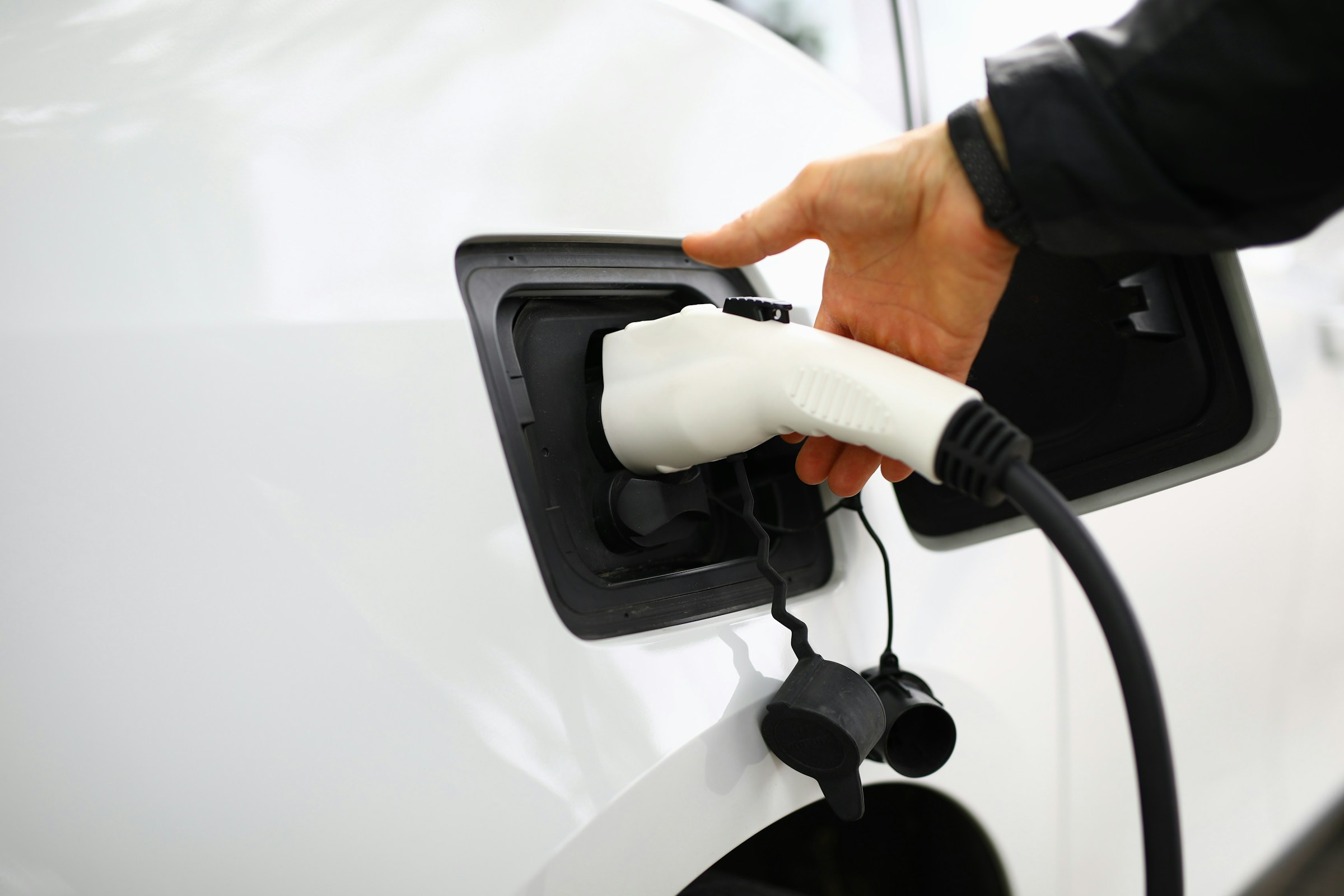 An electric vehicle is plugged into a charging station.