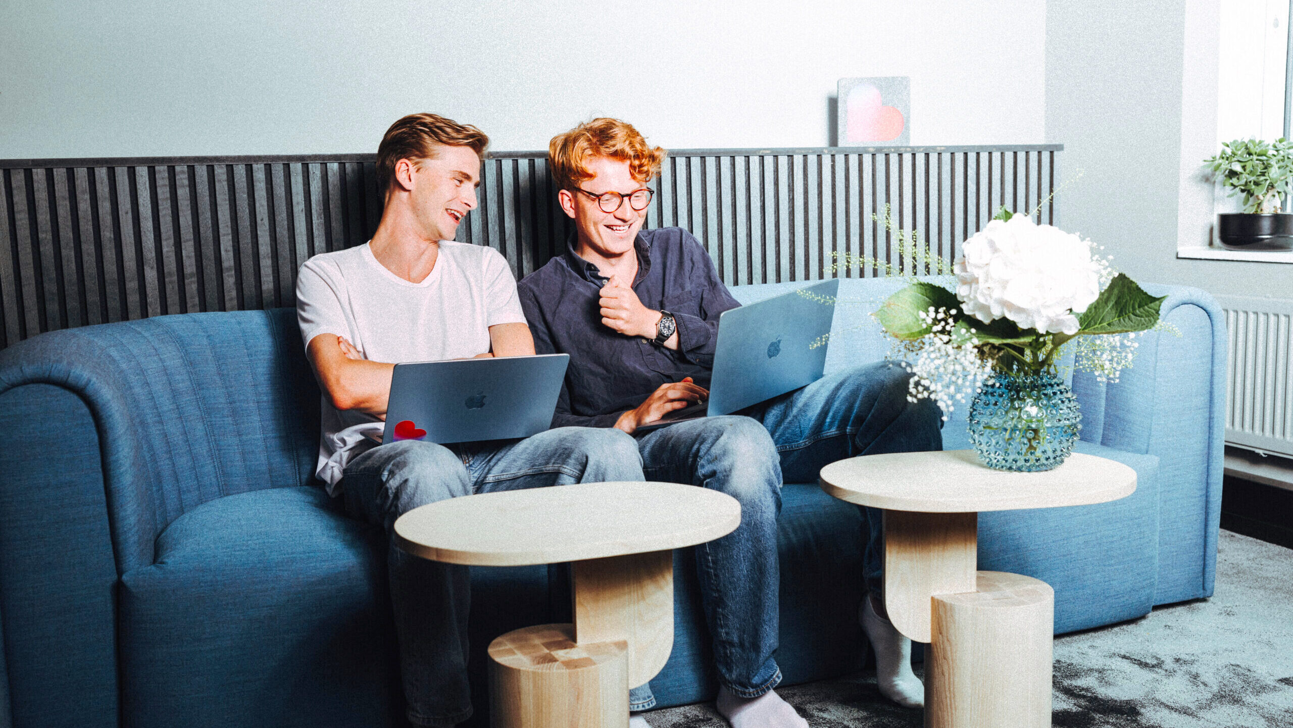 Photo of two people coding on their laptops.