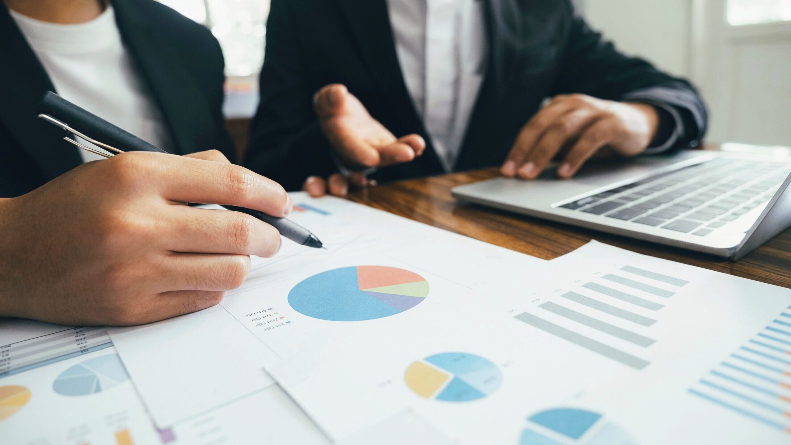 Photo of two people looking at pie charts