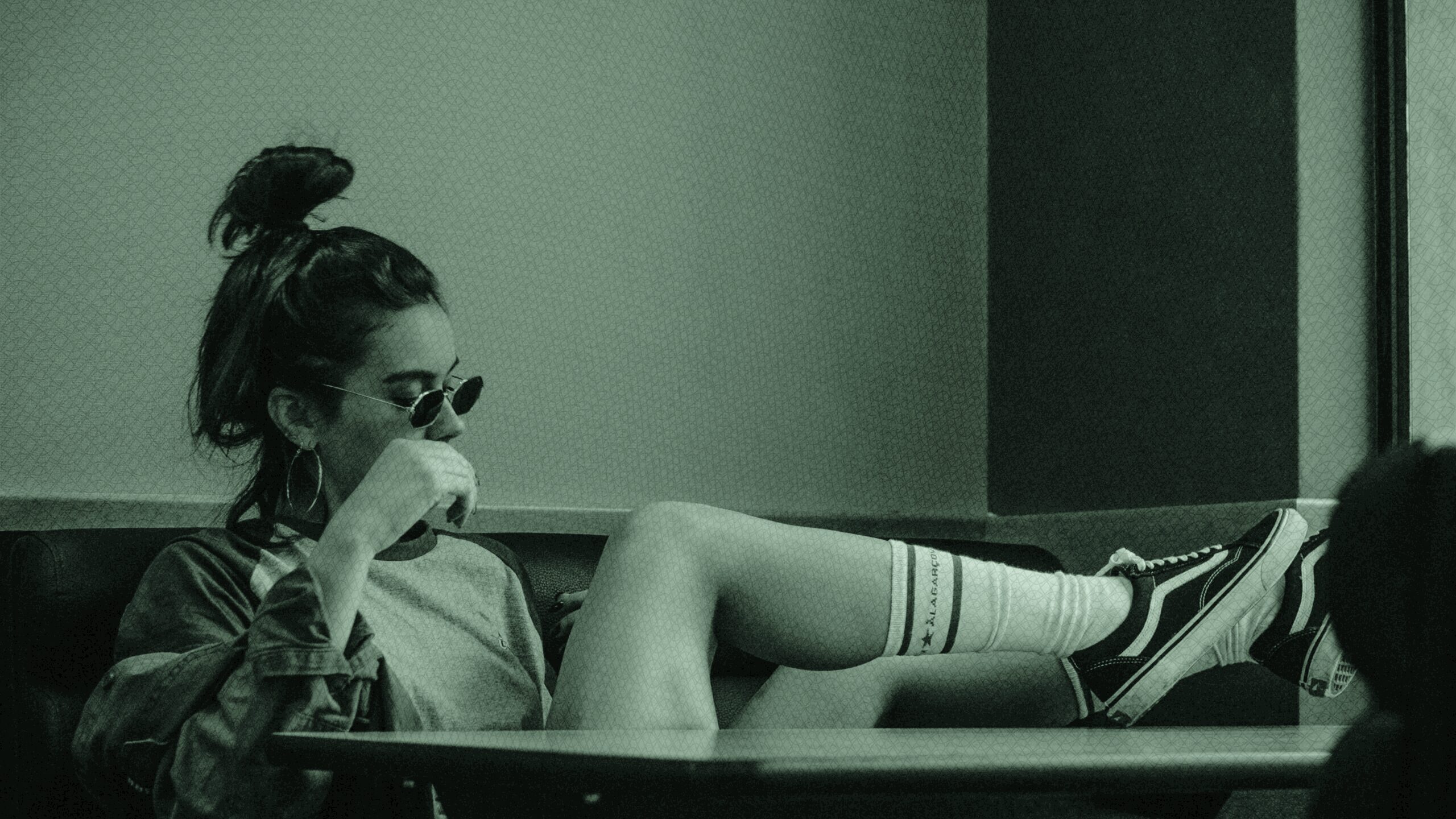 A woman sitting with her leges on her desk.