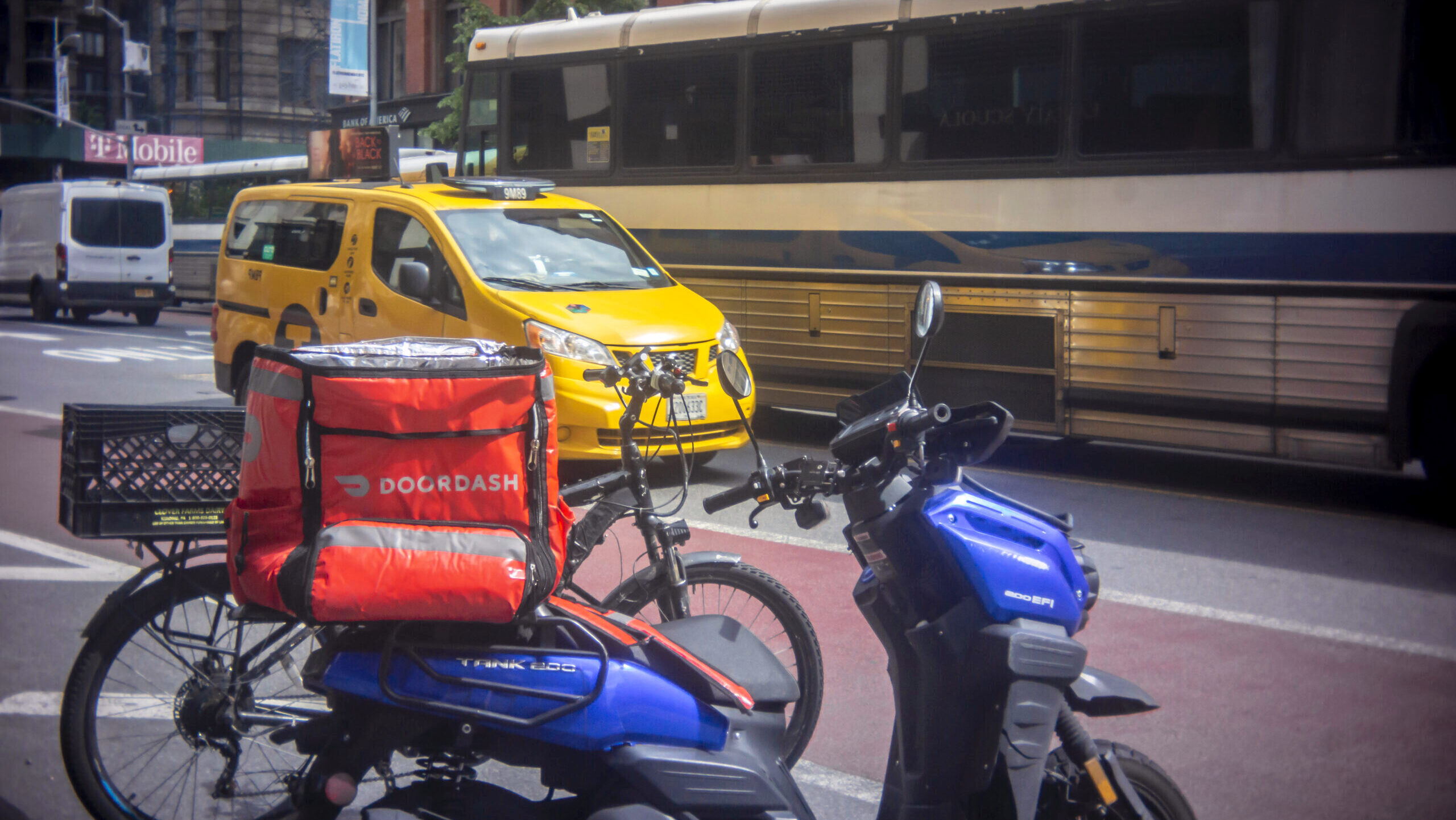 Photo of a scooter with a DoorDash branded tote.