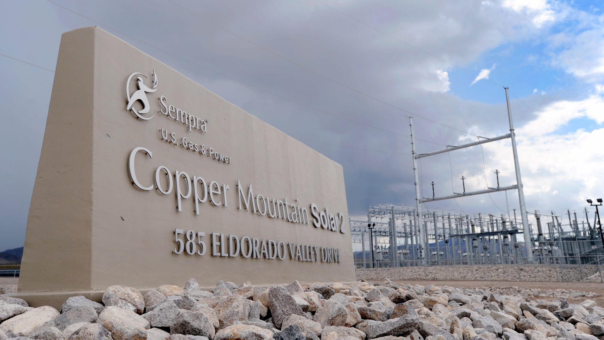 The entrance to Sempra's Copper Mountain Solar 2 array in Nevada is shown with power grid infrastructure visible in the background.