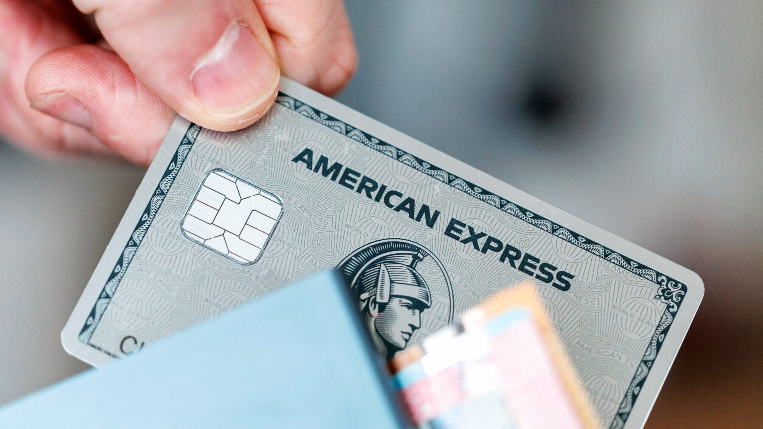 Photo of a hand holding an American Express card.