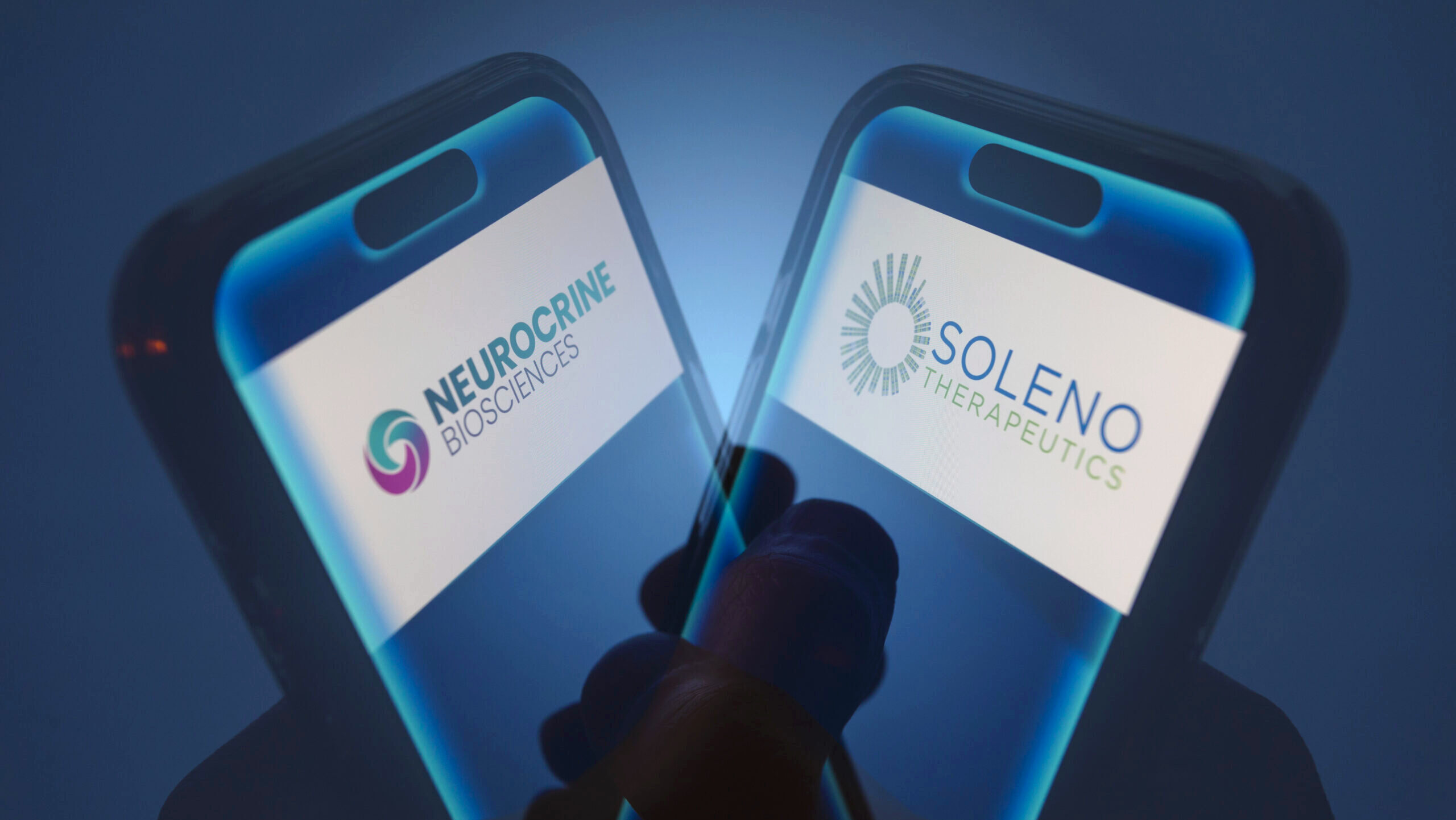 Photo of the Neurocrine Biosciences and Soleno Therapeutics logos on smartphone displays.