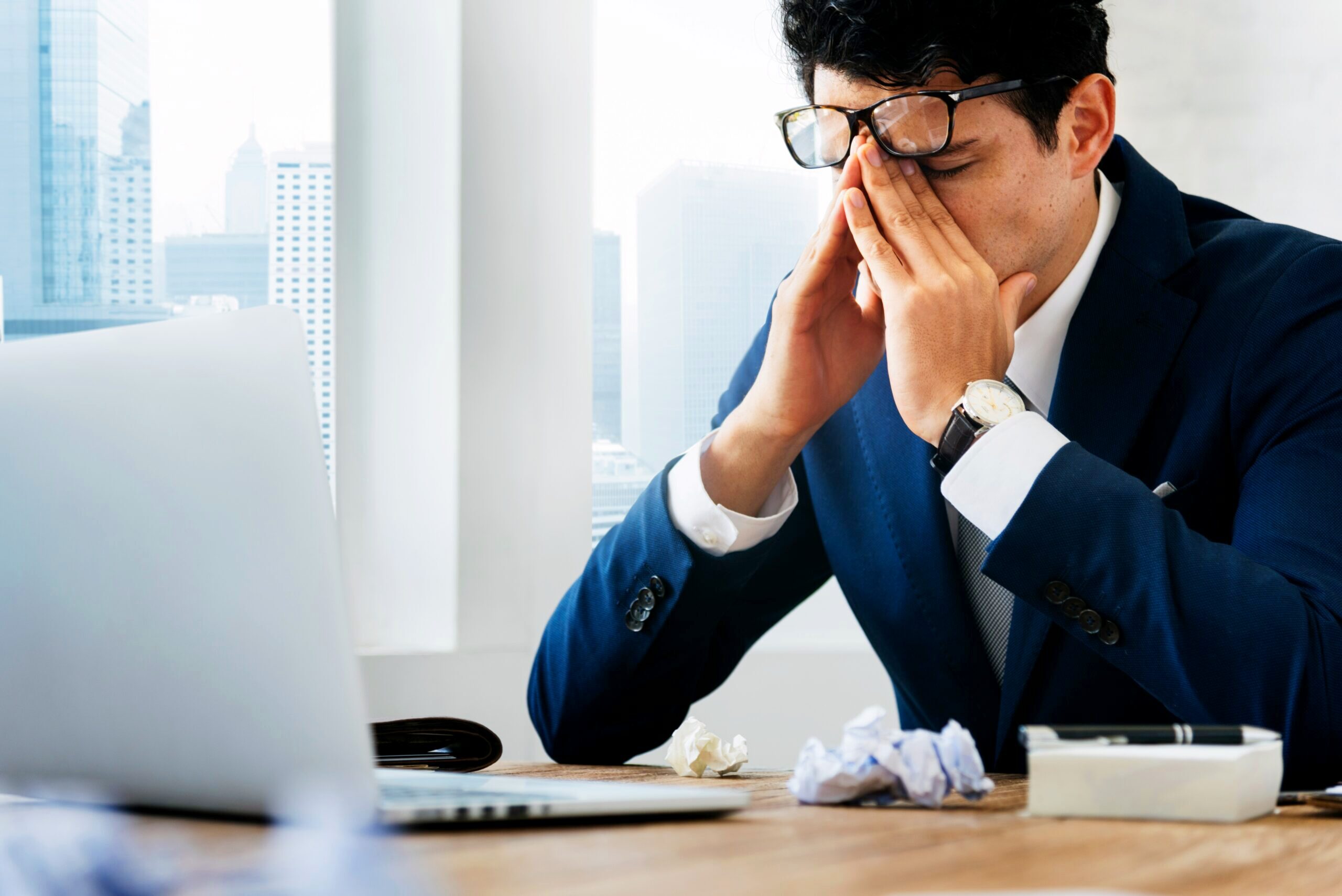 Stressed advisor sitting at a desk.