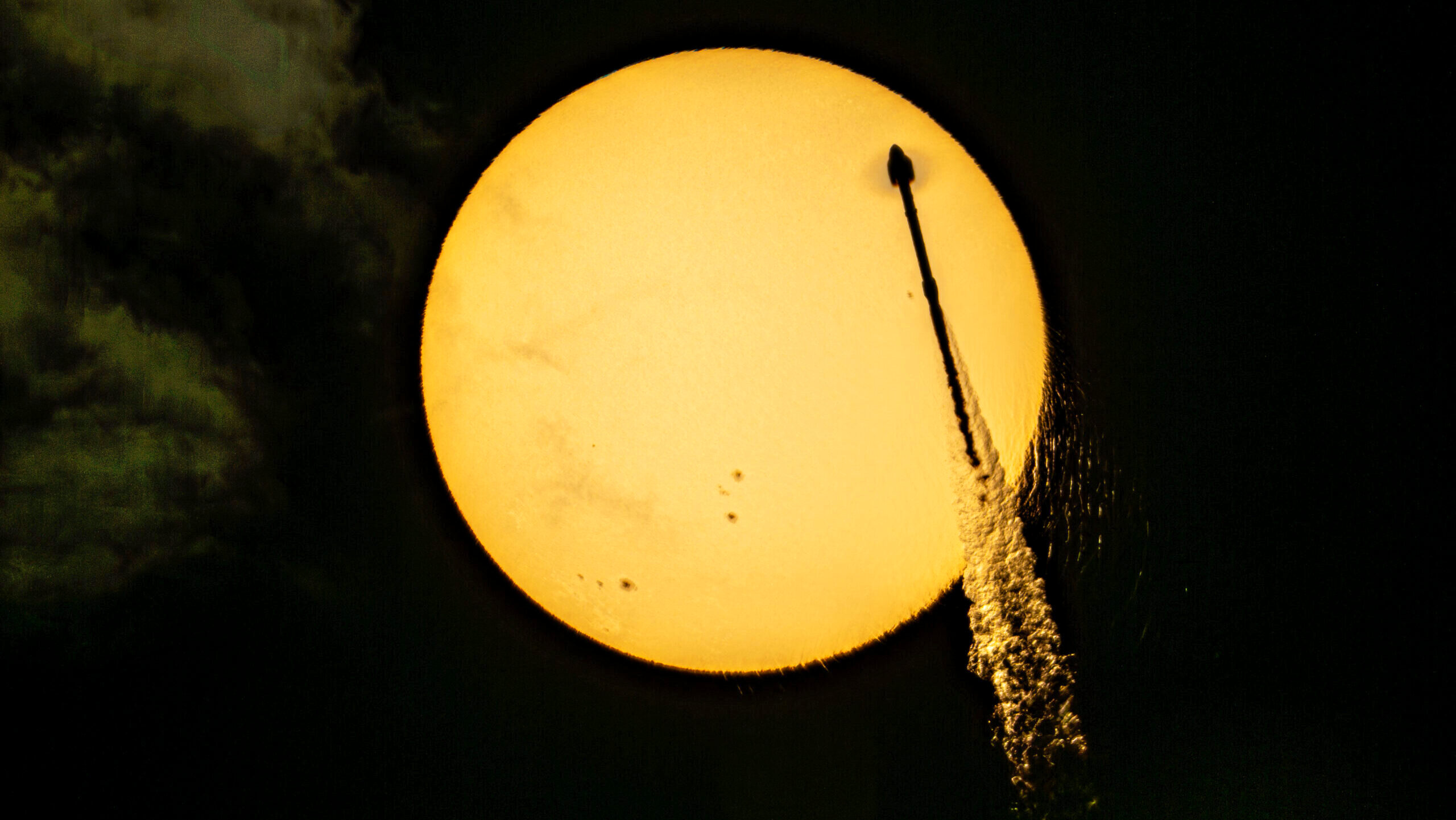 A SpaceX Falcon 9 rocket launches and is seen in front of the moon in the sky on May 25th, 2026.