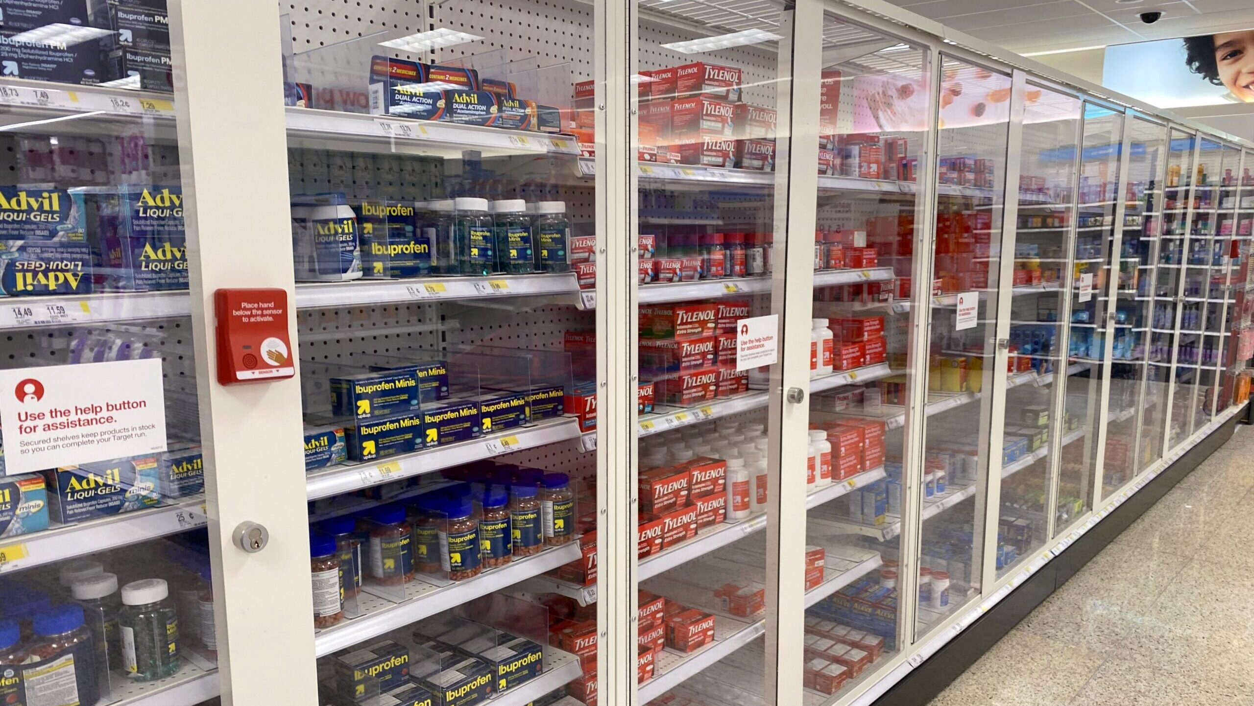 Photo of a locked medicine cabinet in a supermarket aisle.