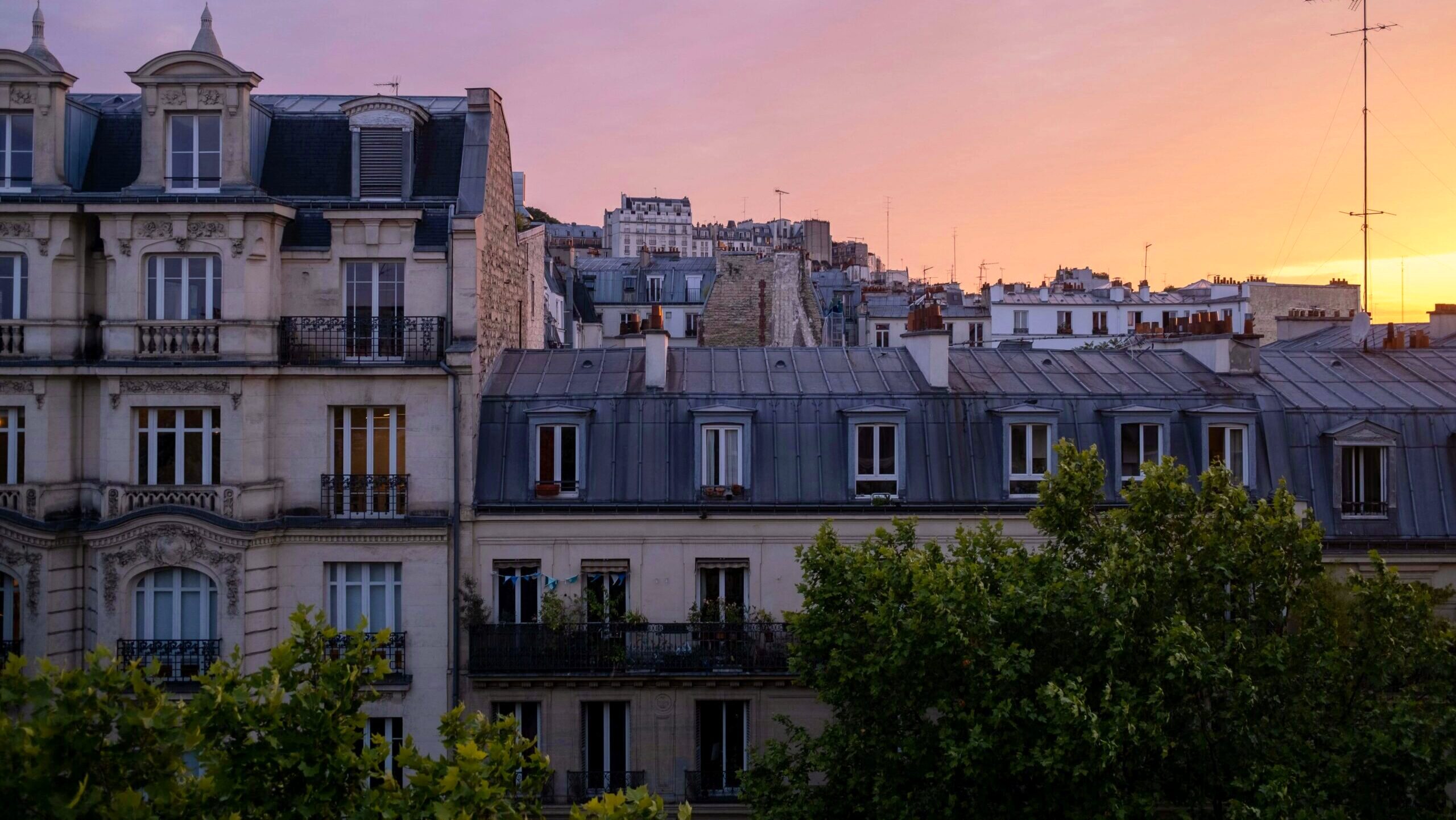 A view of apartment windows in Paris, France at sunset.