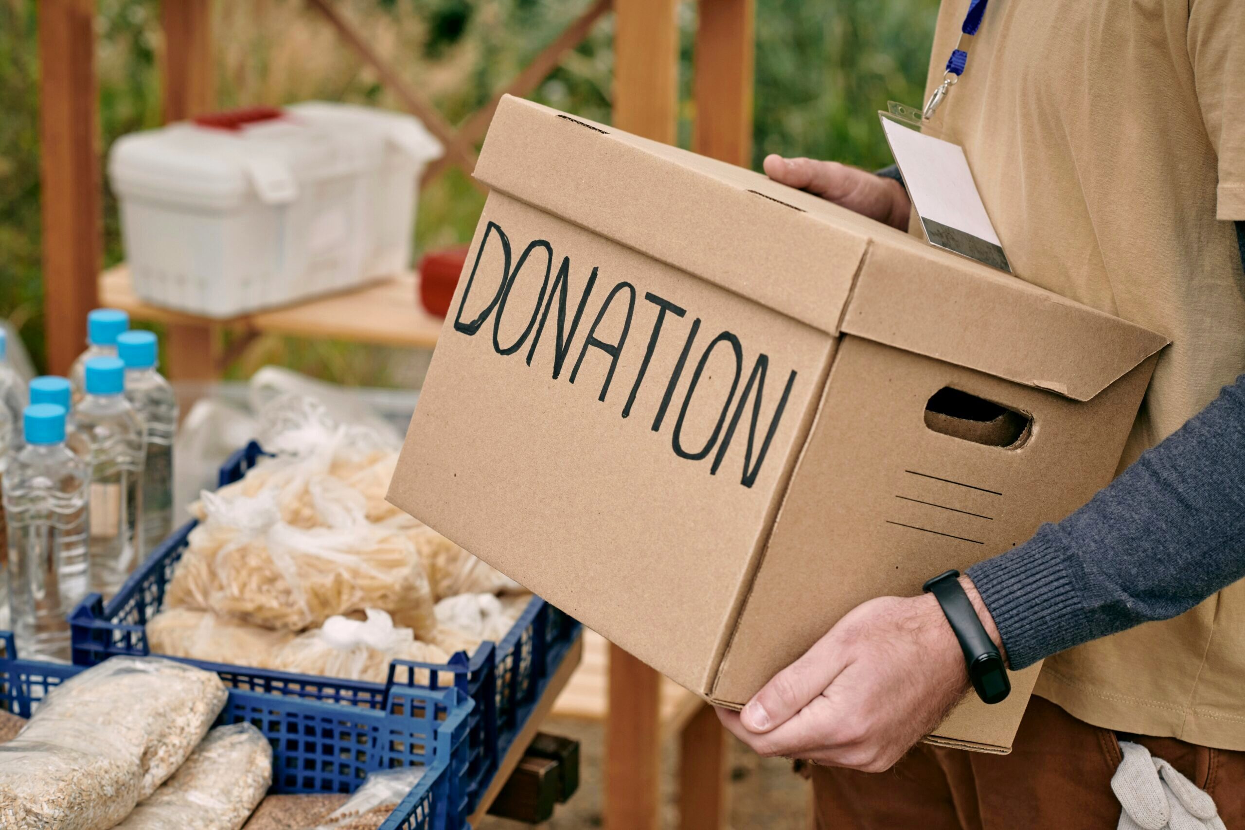 Picture of a person carrying a box with a donation label on it.