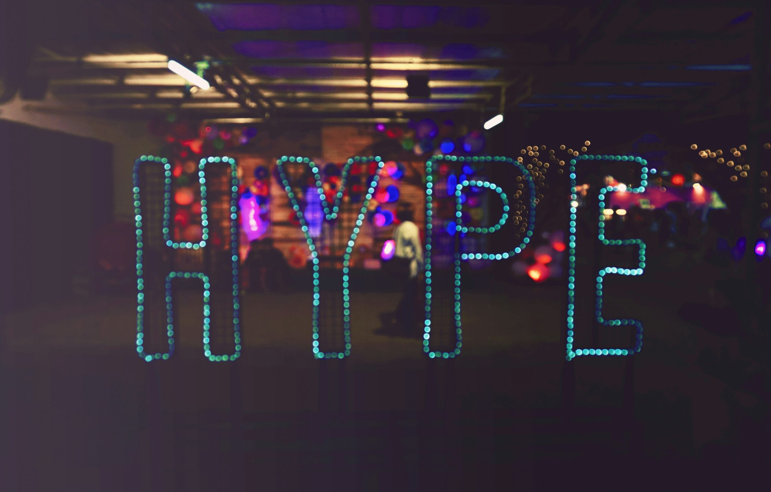 Abstract photo with various colored blue-green lights spelling out the word HYPE.
