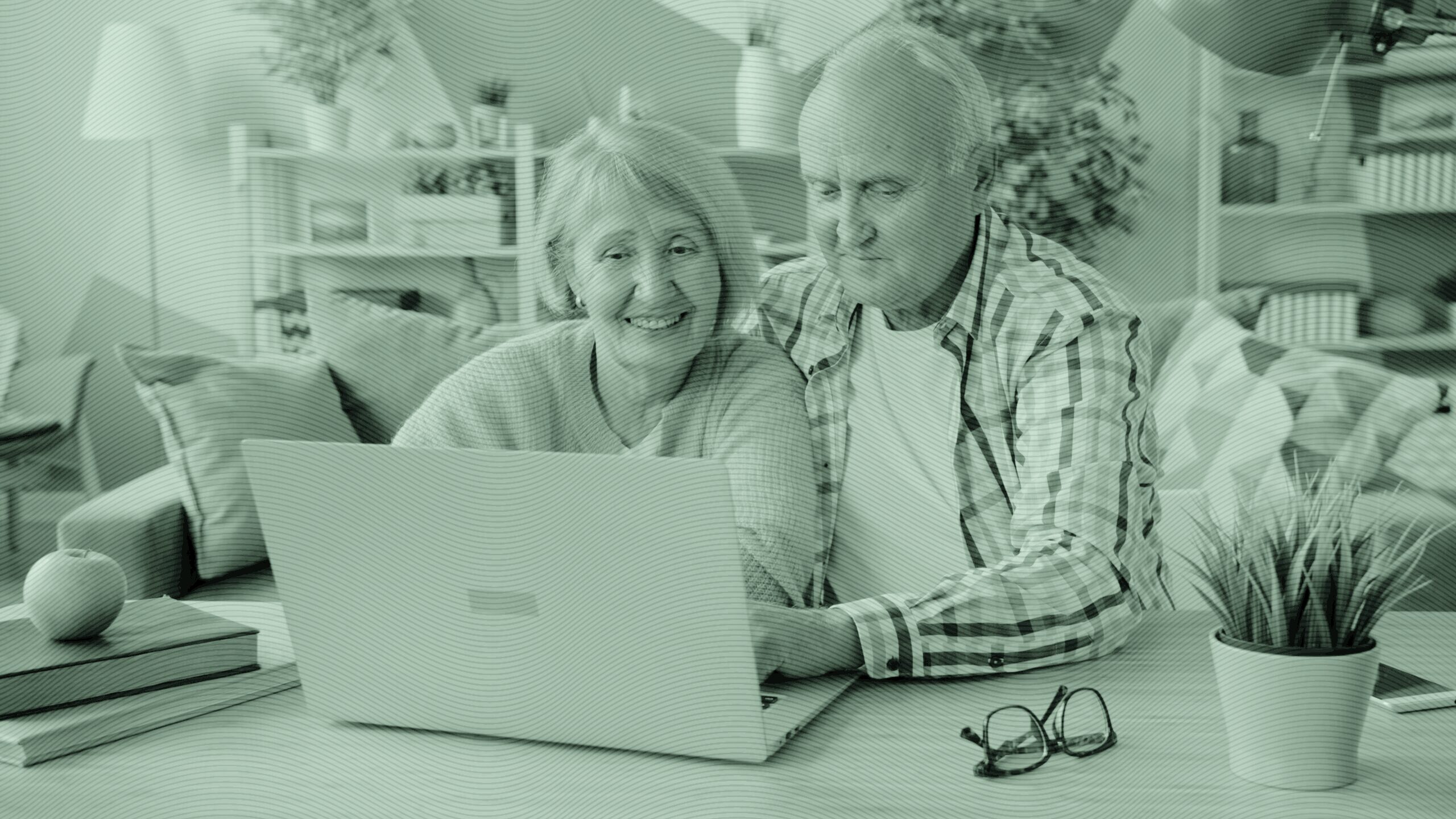 An elderly couple working on their computer.