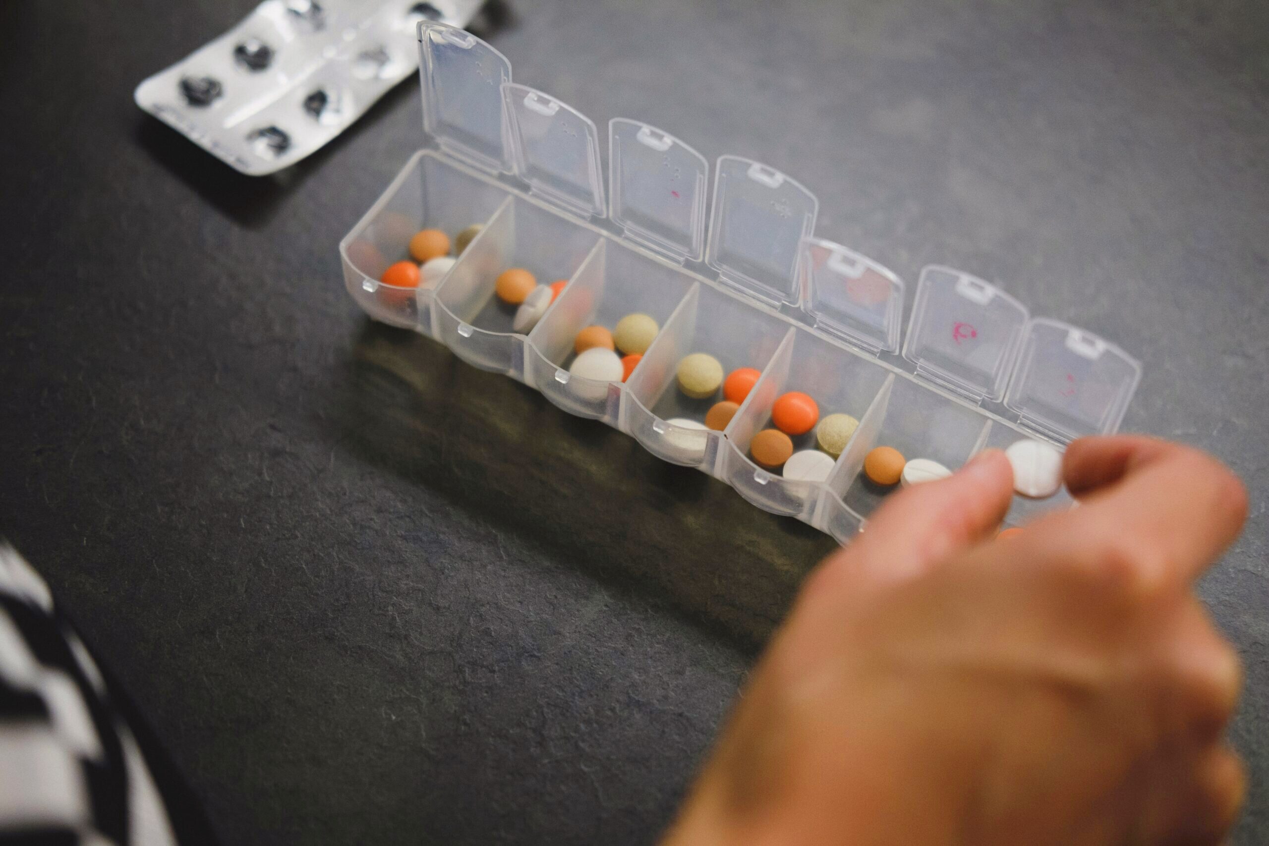 Photo of a pill container filled with various types of medication.