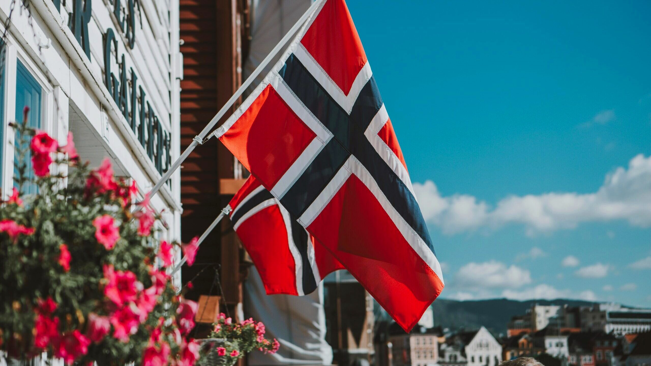 Norwegian flags are shown hanging in front of a building in Bergen, Norway.